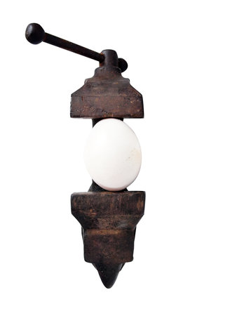 conceptual photo of a egg in a vise about to crack under pressureの写真素材