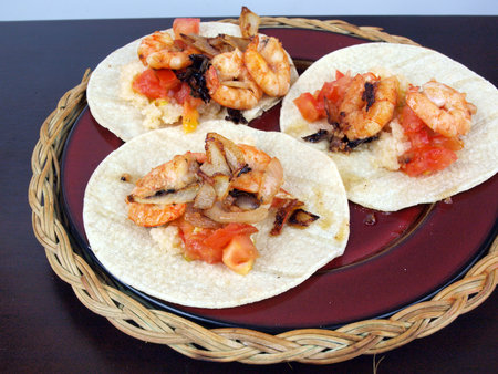 plate of shrimp tacos on a wooden tableの写真素材