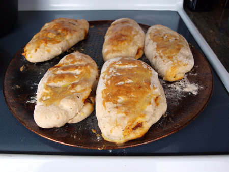 homemade calzones on a pizza tray fresh out the ovenの写真素材