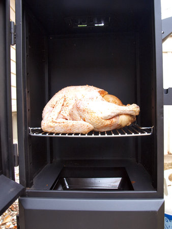 a whole turkey being cooked in a propane smoker grillの写真素材
