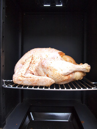 a whole turkey being cooked in a propane smoker grillの写真素材