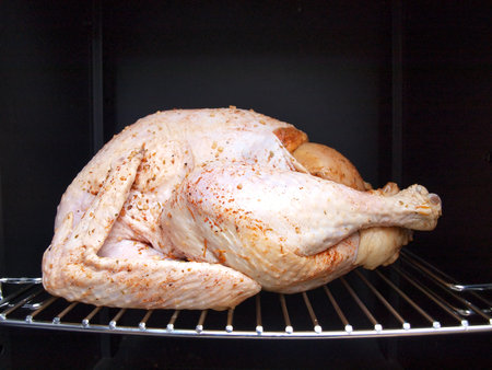 a whole turkey being cooked in a propane smoker grillの写真素材