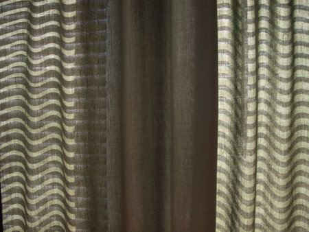 photo of light shining through blinds underneath a green curtainの写真素材