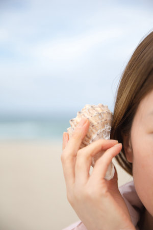 A woman listening to the sound of the sea in Soraの写真素材