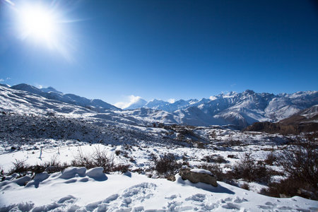 the sun shines in the high snowy mountains of Himalayasの写真素材