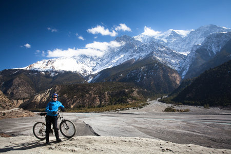 Girl with a bicycle in the high mountains Himalayas  Annapurna trackの写真素材