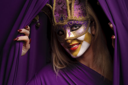 smiling woman in violet mask open curtain, may be use for theater conceptの写真素材