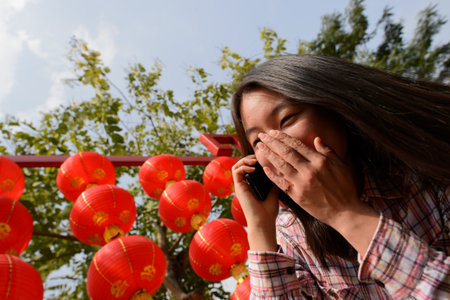 Chinese woman talking on cell phone during chinese new year