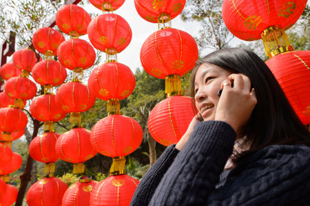 Chinese woman talking on cell phone during chinese new yearの写真素材
