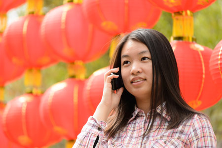 Chinese woman talking on cell phone during chinese new yearの写真素材