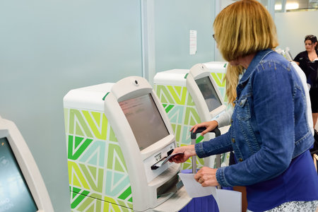 ROME, ITALY - AUGUST 16, 2015: woman use self check-in kiosks in Fiumicino Airport. Fiumicino -...