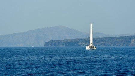 SANTORINI, GREECE - AUGUST 06, 2015: people on yacht near Santorini sea coast. Santorini, classically Thera, and officially Thira, is an island in the southern Aegean Sea, about 200 km southeast of Greece's mainland.のeditorial素材
