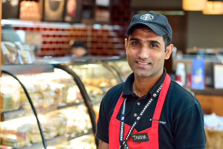 DUBAI, UAE - NOVEMBER 16, 2015: barista in Starbucks cafe in Dubai Airport. Dubai International...