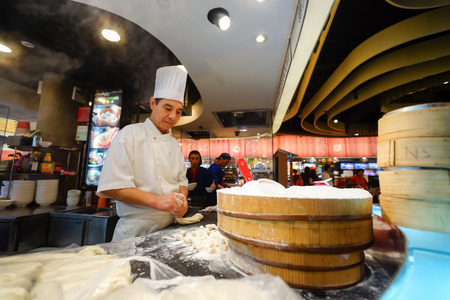 SINGAPORE - NOVEMBER 08, 2015: cook prepare food on the food court of The Shoppes at Marina Bay Sands. The Shoppes at Marina Bay Sands is one of Singapore's largest luxury shopping mallsのeditorial素材