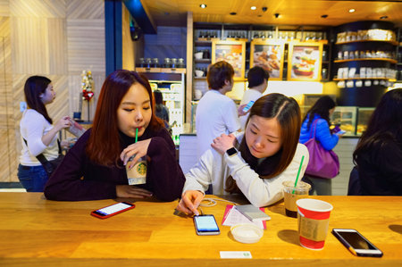 HONG KONG - DECEMBER 25, 2015: customers of Starbucks cafe. Starbucks Corporation is an American global coffee company and coffeehouse chain based in Seattle, Washingtonのeditorial素材