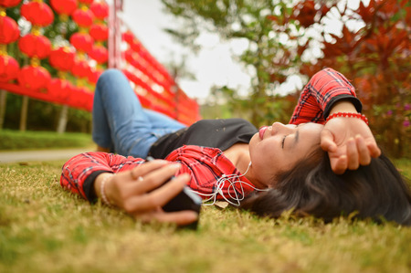 Chinese woman use smartphone in the park during chinese new yearの写真素材