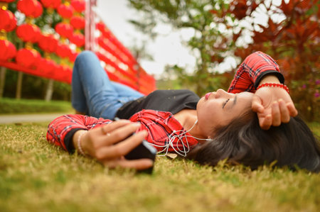 Chinese woman use smartphone in the park during chinese new year