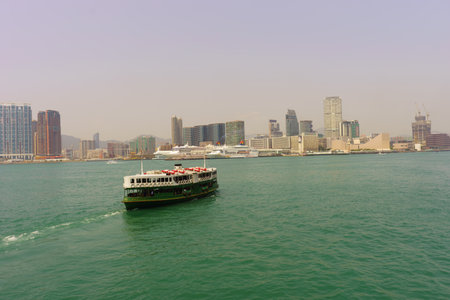 HONG KONG - APRIL 16, 2015: ferry across Victoria Harbour. The Star Ferry, or The "Star" Ferry Company, is a passenger ferry service operator and tourist attraction in Hong Kongのeditorial素材