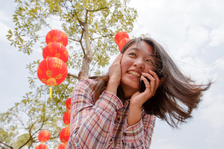 Chinese woman talking on cell phone during chinese new yearの写真素材