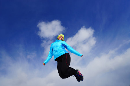 Young woman making exercises on a snow fieldの写真素材