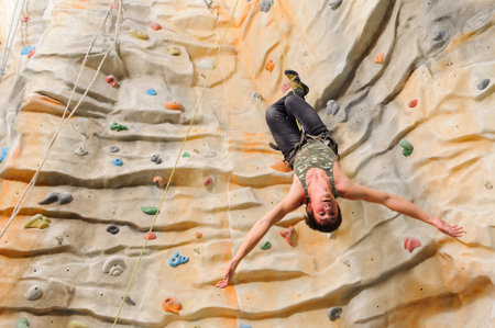 Man climbing on man-made cliff in the sport centre