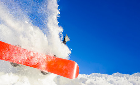 young man on the snowboard jumping over the slope in winterの写真素材