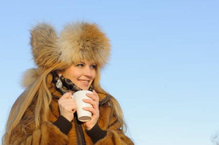 Outdoor portrait of young caucasian woman in fur hat