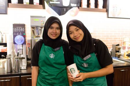 LANGKAWI - APRIL 30: starbucks staff posing for photo on April 30, 2014 in Langkawi, Malaysia. Starbucks is the largest coffeehouse company in the world, with 23,187 storesのeditorial素材