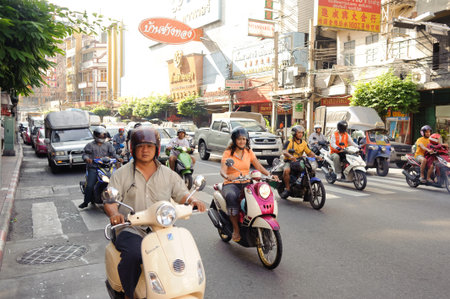 BANGKOK - OCT 26: people drive scooters on streets of Bangkok on October 26, 2011 in Bangkok, Thailand. Bangkok is the capital and the most populous city of Thailand. It is known in Thai as Krung Thep Maha Nakhonのeditorial素材