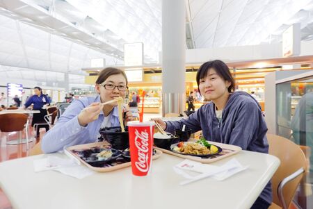 HONG KONG, CHINA - APRIL 11: Korean girl eat Japanese food in Hong Kong International Airport on April 11, 2010 in Hong Kong, China. The one of the best airport in the annual passenger survey by Skytrax.のeditorial素材