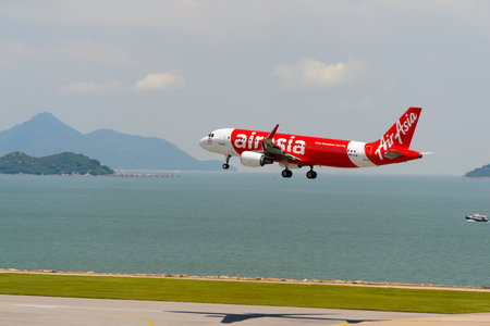 HONG KONG - JUNE 04, 2015: Air Asia aircraft landing at Hong Kong airport. AirAsia Berhad is a Malaysian low-cost airline headquartered near Kuala Lumpur, Malaysia.のeditorial素材