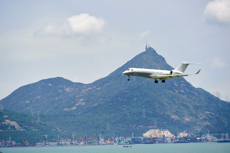 HONG KONG - JUNE 04, 2015: Bombardier Global Express aircraft landing at Hong Kong airport. The Bombardier Global Express is a large cabin, ultra long range business jet manufactured by Bombardier Aerospace in Toronto, Ontario, Canada.のeditorial素材