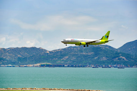 HONG KONG - JUNE 04, 2015: Jin Air aircraft landing at Hong Kong airport. Jin Air Co. Ltd is a low...