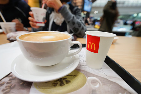 HONG KONG - JANUARY 29, 2016: close up shot of cup with flat white coffee on the table at McCafe. McCafe is a coffee-house-style food and drink chain, owned by McDonald's.のeditorial素材