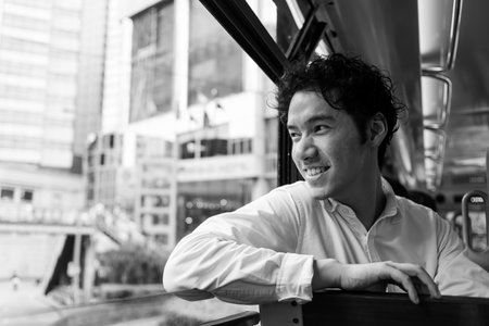 Young man in double decker tramway in Hong Kongの写真素材