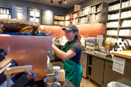 NEW YORK - CIRCA MARCH 2016: worker at Starbucks Cafe. Starbucks Corporation is an American global coffee company and coffeehouse chain based in Seattle, Washingtonのeditorial素材
