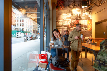 NEW YORK - CIRCA MARCH 2016: woman in Starbucks Cafe. Starbucks Corporation is an American global...