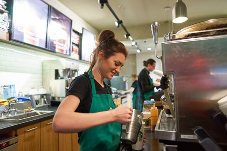 SAINT PETERSBURG, RUSSIA - MARCH 12, 2016: worker at Starbucks Cafe. Starbucks Corporation is an American global coffee company and coffeehouse chain based in Seattle, Washingtonのeditorial素材