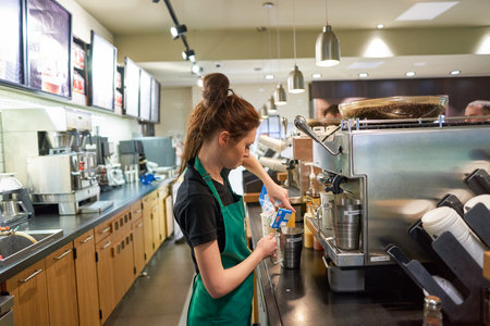 SAINT PETERSBURG, RUSSIA - MARCH 12, 2016: worker at Starbucks Cafe. Starbucks Corporation is an American global coffee company and coffeehouse chain based in Seattle, Washingtonのeditorial素材