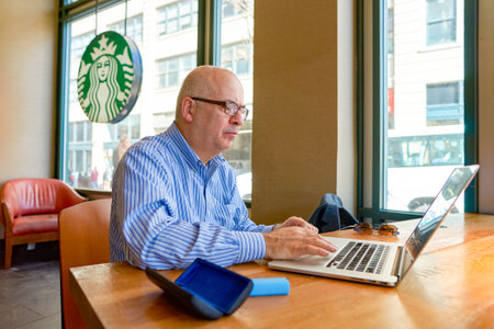 NEW YORK - CIRCA MARCH 2016: man in Starbucks Cafe. Starbucks Corporation is an American global coffee company and coffeehouse chain based in Seattle, Washingtonのeditorial素材