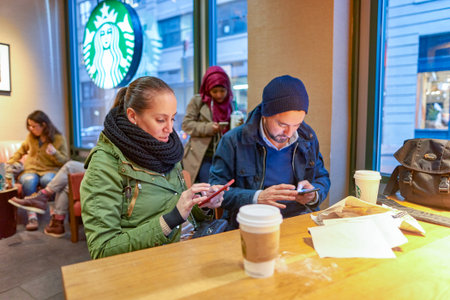NEW YORK - CIRCA MARCH 2016: people in Starbucks Cafe. Starbucks Corporation is an American global...