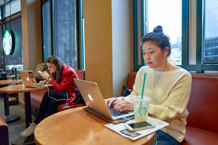 NEW YORK - CIRCA MARCH 2016: woman in Starbucks Cafe. Starbucks Corporation is an American global coffee company and coffeehouse chain based in Seattle, Washingtonのeditorial素材
