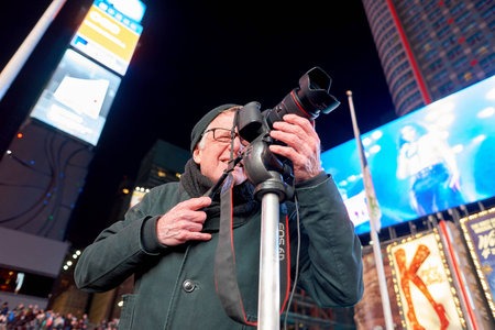 NEW YORK - CIRCA MARCH, 2016: man taking photos in New York at nighttime. The City of New York,...