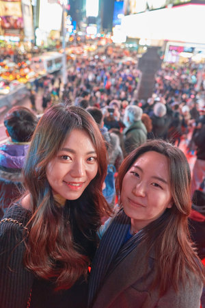 NEW YORK - CIRCA MARCH, 2016: outdoor portrait of young women at Times Square at night time. Times Square is a major commercial intersection and neighborhood in Midtown Manhattan, New York City.のeditorial素材