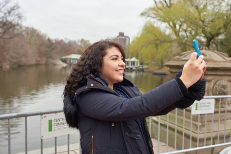 NEW YORK - CIRCA MARCH, 2016: woman taking selfie in Central Park. Central Park is an urban park in middle-upper Manhattan, within New York City.のeditorial素材