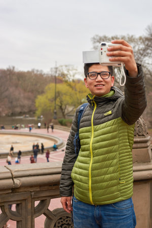 NEW YORK - CIRCA MARCH, 2016: man taking selfie in Central Park. Central Park is an urban park in middle-upper Manhattan, within New York City.のeditorial素材
