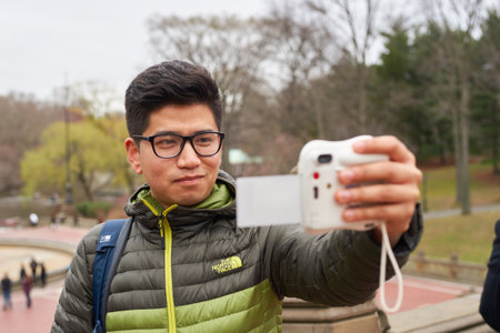 NEW YORK - CIRCA MARCH, 2016: man taking selfie in Central Park. Central Park is an urban park in middle-upper Manhattan, within New York City.のeditorial素材
