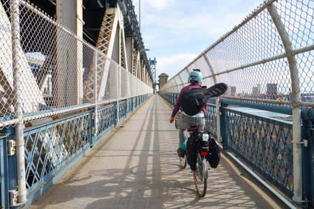 NEW YORK - CIRCA MARCH, 2016: cyclist crosses the Manhattan Bridge in New York. The Manhattan Bridge is a suspension bridge that crosses the East River in New York City,のeditorial素材