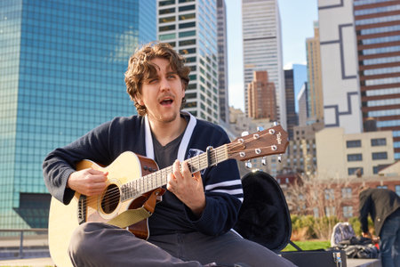 NEW YORK - MARCH 17, 2016: man sing song at Pier 15 at daytime. Pier 15 is located east of South...