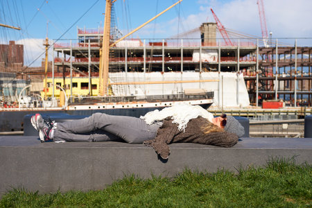 NEW YORK - MARCH 17, 2016: woman take a rest at Pier 15 at daytime. Pier 15 is located east of South Street and FDR Drive in Lower Manhattan, New York City.のeditorial素材